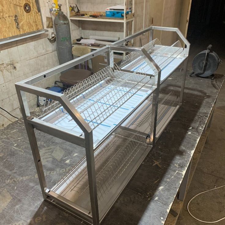 Égouttoir en inox en cours de fabrication sur l'établi de l'atelier