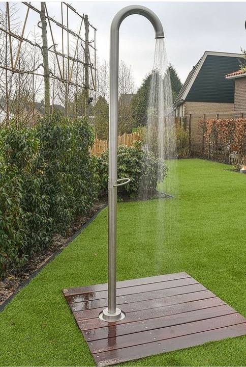 Douche de jardin en inox posée sur un caillebotis