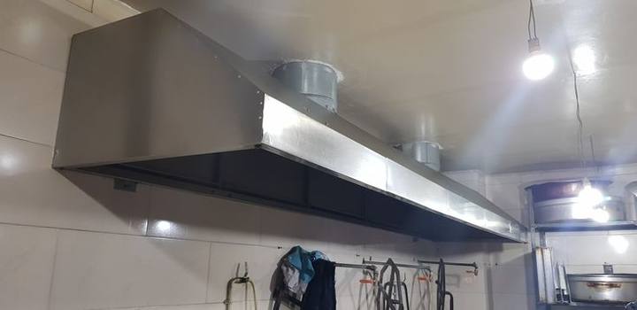 Hotte murale en inox installée dans une cuisine
