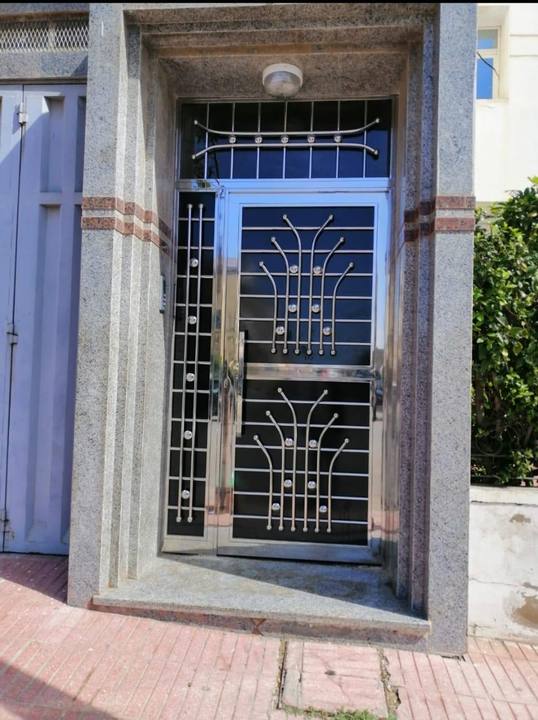 Porte d'entrée en inox avec grille ornementale