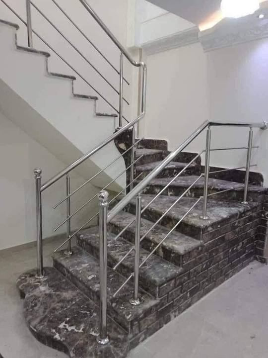 Rampe en inox sur un escalier tournant en marbre